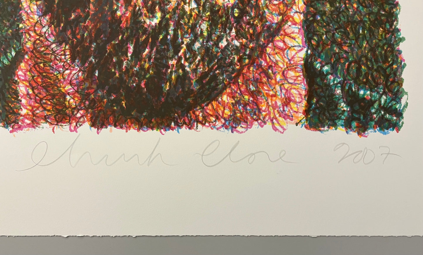 Photo of Chuck Close's signature on the bottom right corner of the artwork.