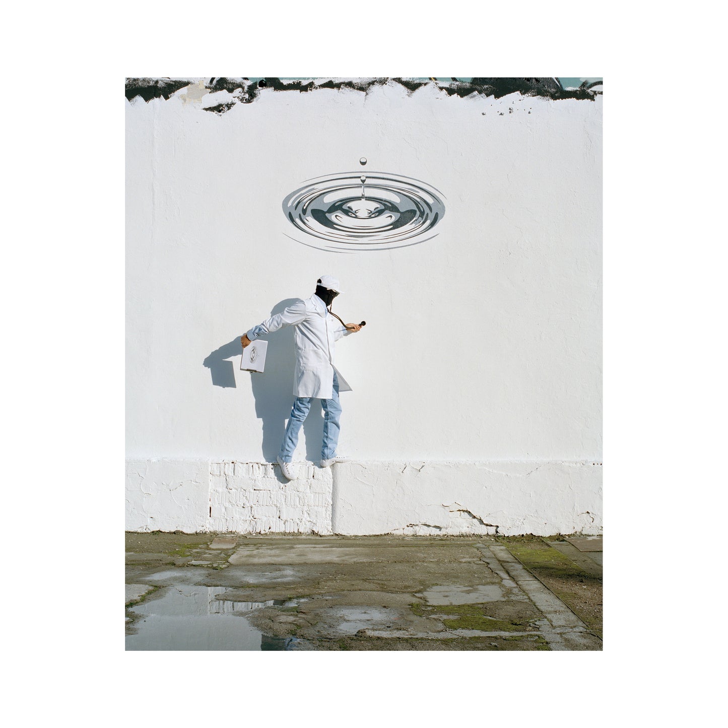“Wall of Water” by Robin Rhode, Conceptual artwork blending realism and surrealism, depicting an artist painting a hyperrealistic water droplet ripple on a stark white wall. The scene's minimalism contrasts with the intricate detail of the ripple.