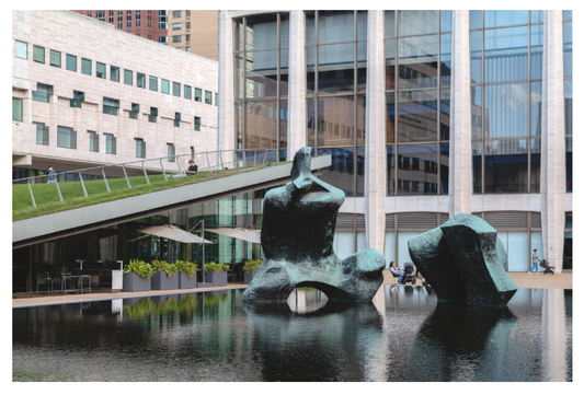 Reclining Figure by Henry Moore, a monumental bronze sculpture positioned within a the Milsteon Reflecting Pool on Lincoln Center's campus, NYC
